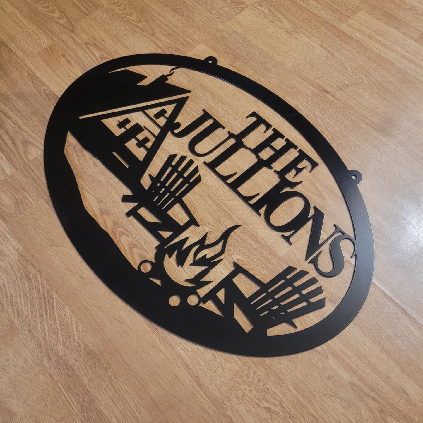 Rustic Oval Metal Sign with A-Frame Cabin and Campfire